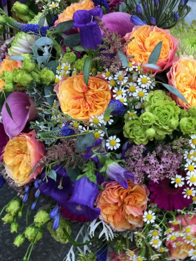 The Radiant Garden - A vibrant bouquet busting with a harmonious blend of warm orange, bright yellow, pops of purple and pink and zesty green, it captures the timeless beauty of a sunlit garden alive with colour - perfect for adding joyful warmth and charm to any occasion or space.