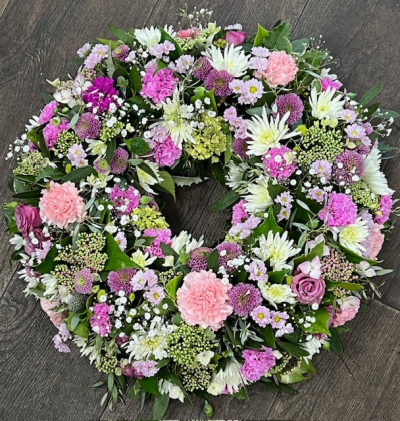 Wreath pastel - Our elegant pastel wreath features a harmonious blend of soft pinks, lilac, white and touches of fresh greenery.  The circular arrangement creatures a balanced and graceful design