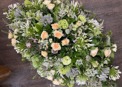 Casket spray neutral - A serene and natural casket spray, crafted with gentle creams, soft peaches and subtle green tones - wisps of delicate blossoms and fresh foliage create a graceful meadowlike look