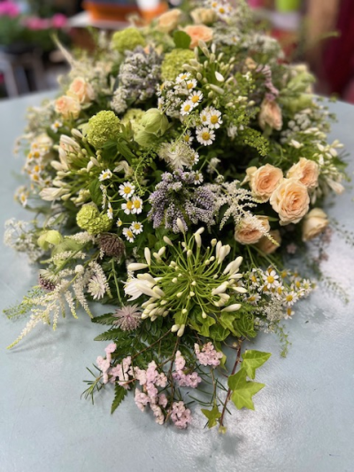 Single end spray neutral - This elegant single ended funeral spray features a soothing palette of soft creams and peach, gentle greens and delicate whites
