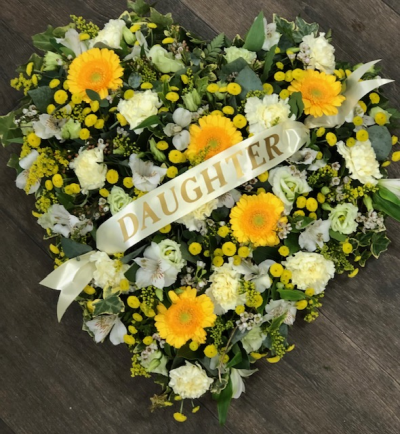 Heart bright - Inspired by the gentle radiance of a summer meadow, this heart-shaped design glows with the warmth of golden blooms, softened by fresh whites and touches of delicate greenery.