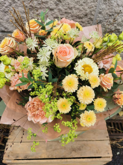 Bouquet of the week - This bouquet has a very soft, romantic, and fresh feel with its peach roses, pale yellow chrysanthemums, light green accents, and touches of natural foliage.