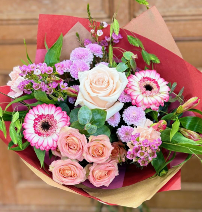 Blush Promise - A love letter written in soft light and gentle color. Creamy whispers of blush melt into tender pinks, kissed by deeper rosy accents that pulse like a quiet heartbeat. Each curve and petal-like shape feels gathered by hand, as if love itself lingered a moment longer while choosing what to keep. Wrapped in warm hues that echo devotion and depth, this bouquet carries the sweetness of beginnings and the comfort of something meant to last. It doesn’t shout—it stays, glows, and promises.