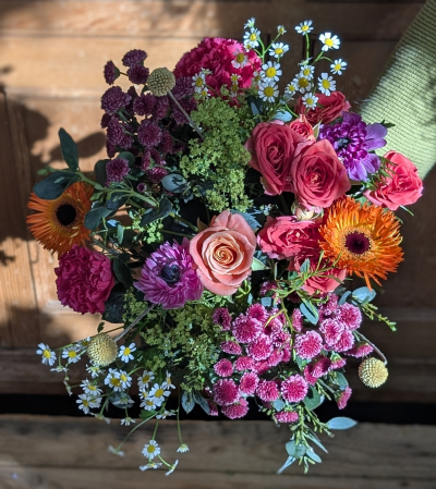 Sunlite embrace - Sunlit Embrace is a joyful celebration of love in full bloom — a radiant gathering of soft blush tones, vibrant corals, rich berry hues, and cheerful pops of sunshine orange. Delicate starry accents dance between lush, velvety petals, while airy greenery adds a fresh, garden-picked feel.

Designed to feel like a warm hug in floral form, this bouquet captures the tenderness, strength, and beauty of motherhood. It’s abundant yet elegant, bright yet heartfelt — the perfect way to say “thank you” for every comforting word, every selfless act, and every unconditional moment of love.

A truly uplifting arrangement for a mother who brings color and light to every day.