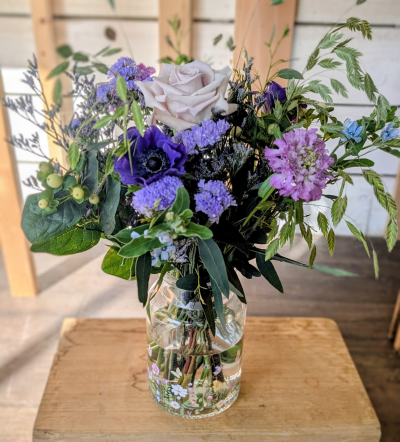 A vase of seasonal flowers - Celebrate the beauty of the season with a naturally elegant vase arrangement designed to make Mother’s Day feel extra special. This hand-tied bouquet brings together a thoughtful mix of fresh seasonal blooms, delicate textures, and soft, airy foliage, all carefully arranged in a charming glass vase.

Each arrangement is created with the best flowers available at the time, giving it an organic, garden-gathered feel with layers of shape and movement. The combination of statement blooms, smaller clustered flowers, and fresh greenery creates a balanced design that feels both relaxed and refined.

Perfect for brightening a table, bedside, or kitchen counter, the flowers arrive ready to enjoy — simply place the vase and let the natural beauty of the season speak for itself.

Because we work with seasonal stems, every arrangement will be slightly unique, making each one a thoughtful and one-of-a-kind gift for someone special this Mother’s Day.