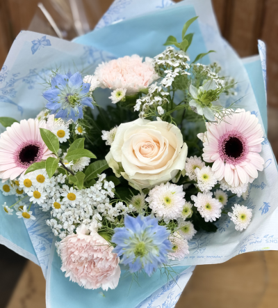 Summer whisper - Delicate, romantic, and effortlessly elegant, this hand-tied bouquet captures the gentle beauty of a summer morning. Soft blush tones, creamy ivory, powder blue, and fresh white combine to create a light and airy arrangement filled with texture and natural movement. Inspired by wildflower meadows and country gardens, it offers a timeless, graceful look perfect for thoughtful gifts, celebrations, or simply bringing a touch of serenity indoors.
The colour palette and overall style of this bouquet will remain as pictured. Due to seasonal availability and daily market variations, individual blooms may be substituted with equally beautiful alternatives. Our florists will always maintain the bouquet's soft pastel colouring, delicate character, and premium presentation.